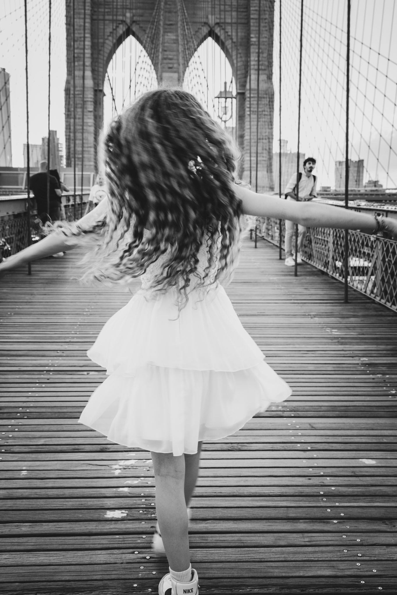 girl posing on Brooklyn bridge wearing a white dress