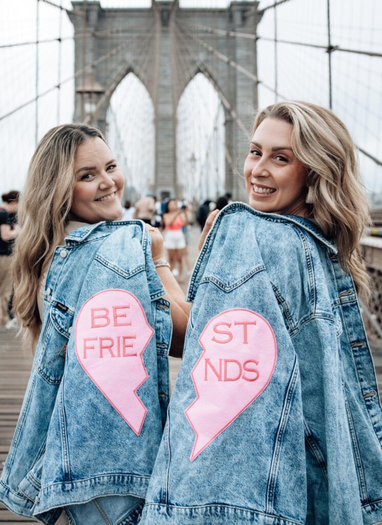 best friends taking a picture on Brooklyn bridge in New York City