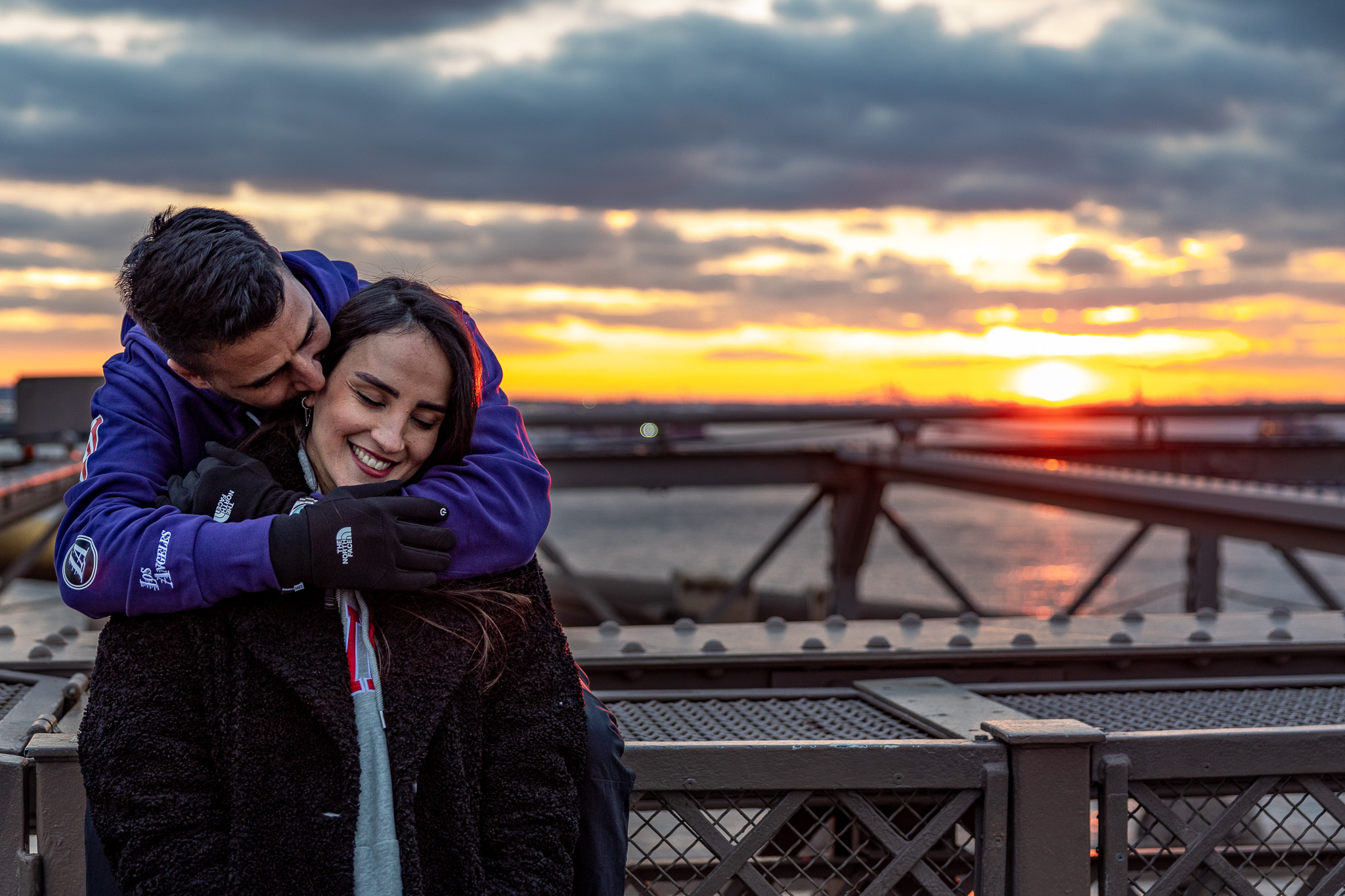 man and woman on Brooklyn bridge during sunset in New York City