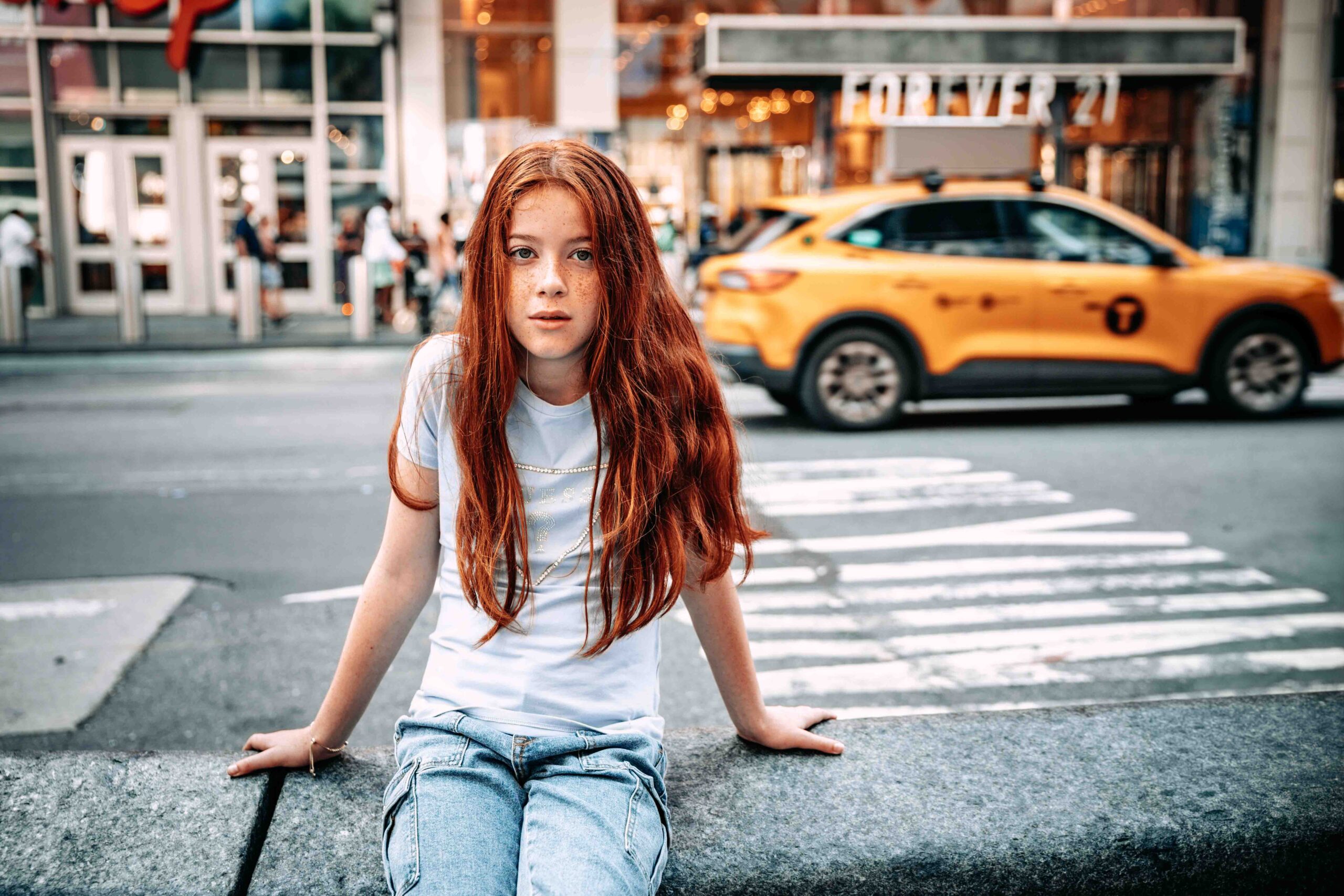 girl taking pictures in Times Square with yellow cab in New York City